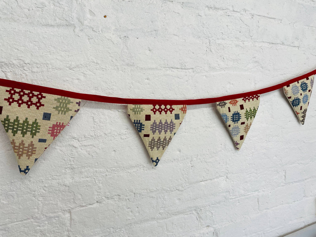 Fabric bunting with geometric patterns on a white textured background