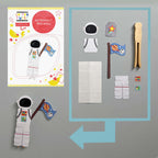 Astronaut peg doll set with paper pieces and a peg on a gray background