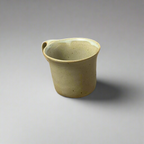 Green ceramic cup on a gray background