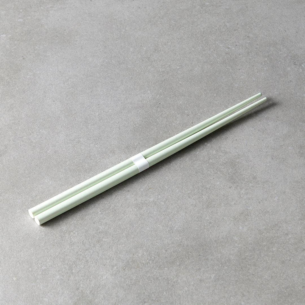 Light green chopsticks on a gray surface