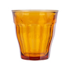 Orange glass tumbler with a textured surface on a white background