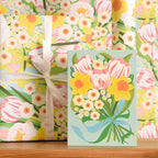 Floral gift wrap with a matching card on a wooden surface