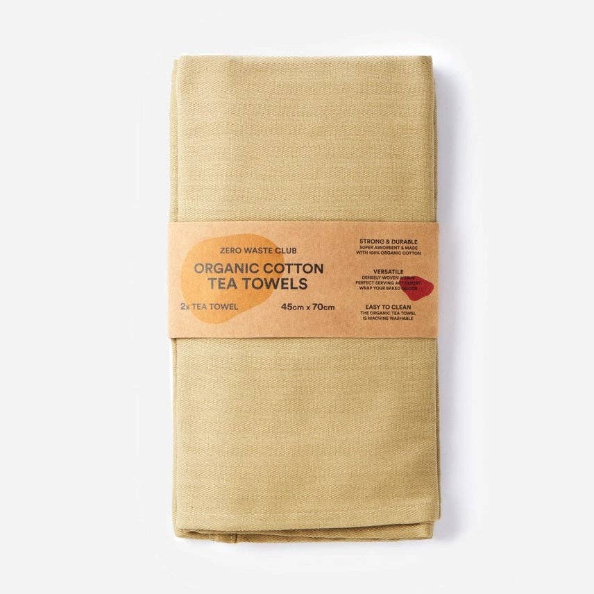 Packaged organic cotton tea towels with a cardboard label on a white background