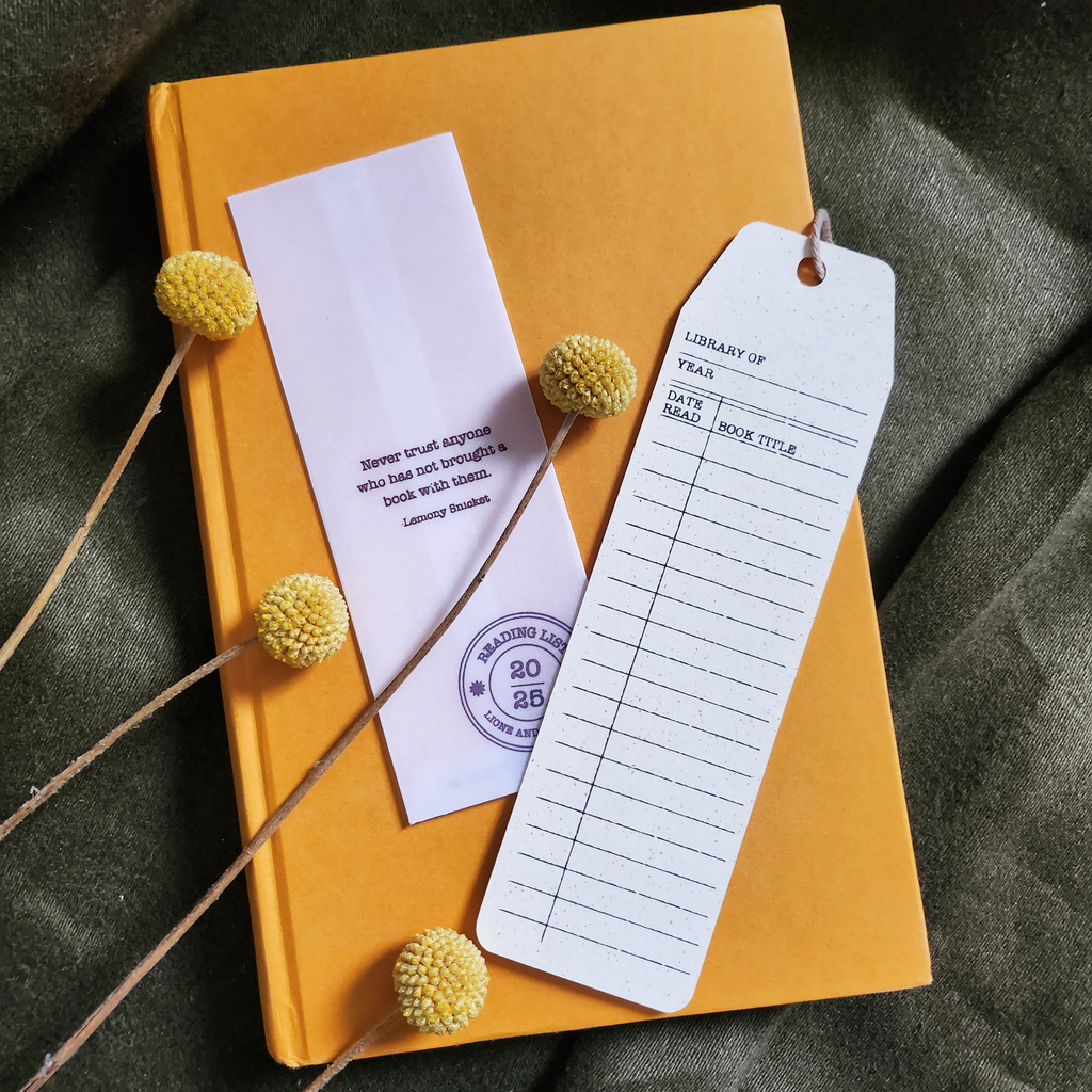 Yellow notebook with a bookmark and library card on a textured surface