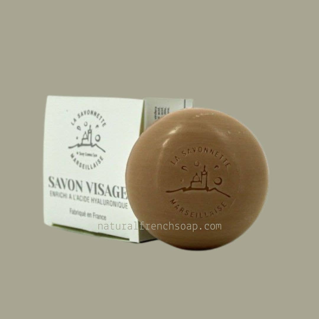 Brown bar of soap with packaging on a beige background