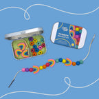 Colorful rainbow bracelet kit with beads and container on a blue background