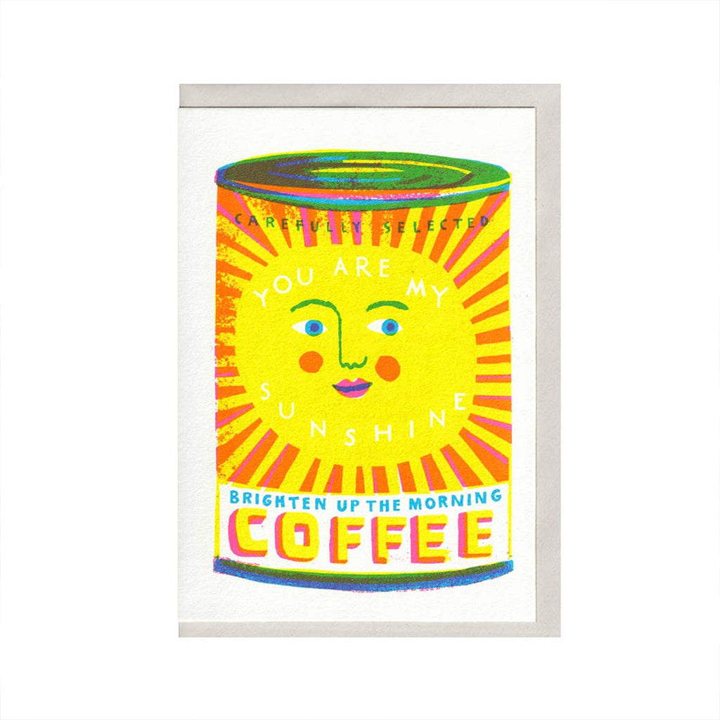 Colorful coffee can card with a face design and text on a white background