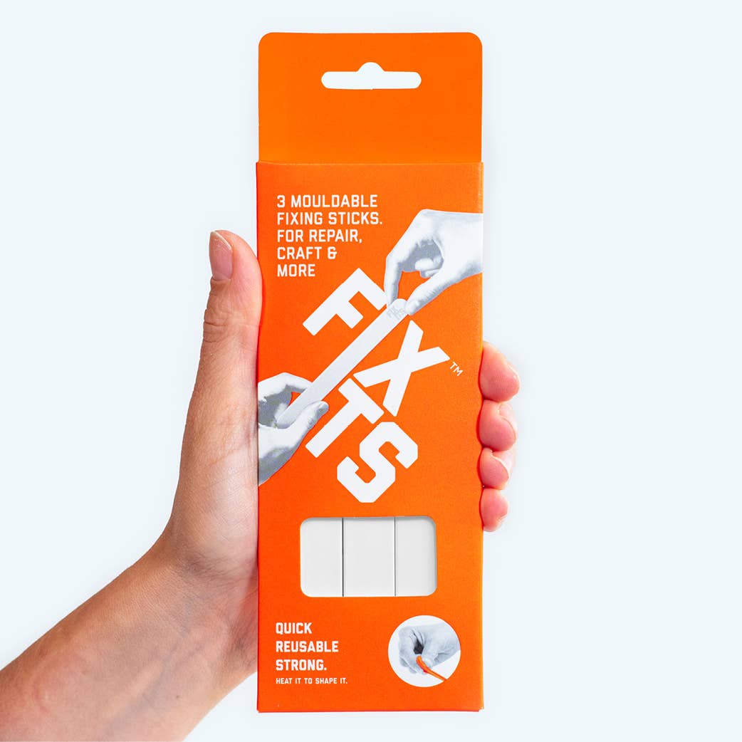 Hand holding an orange FixIts 3-pack against a white background, showing the white brand text - All Good Things