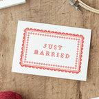 Just Married Wedding Card  with red  Cross Stitch design on a wooden background