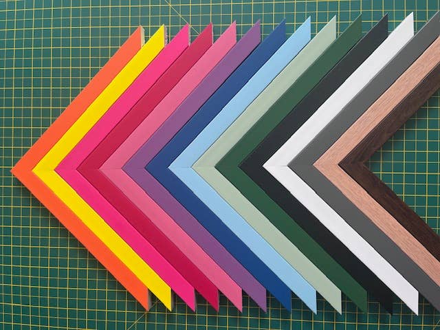 A selection of colourful Polcore picture frames arranged in a geometric rainbow chevron shape - All Good Things