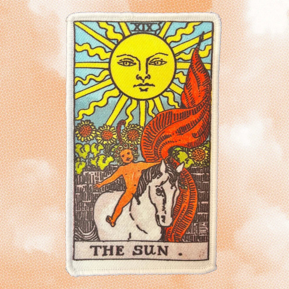 Easy iron on patch for clothing repairs in The Sun tarot card design, on peach textured background
