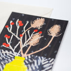 Close up of a greetings card featuring a stylised bouquet of winter berries and teasels in a yellow vase - All Good Things